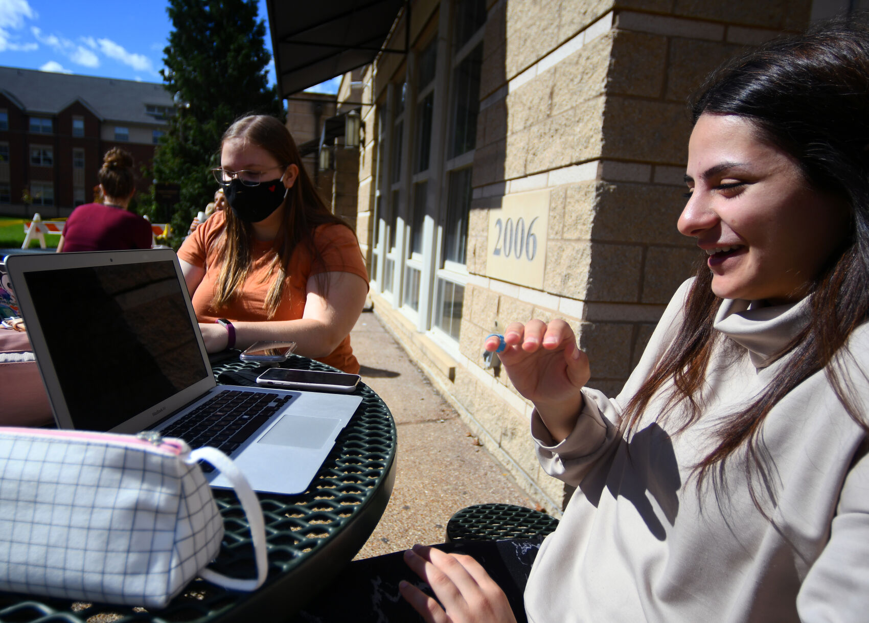Fatima Almansouri, right, laughs at a comment made by her friend Grace Droptiny